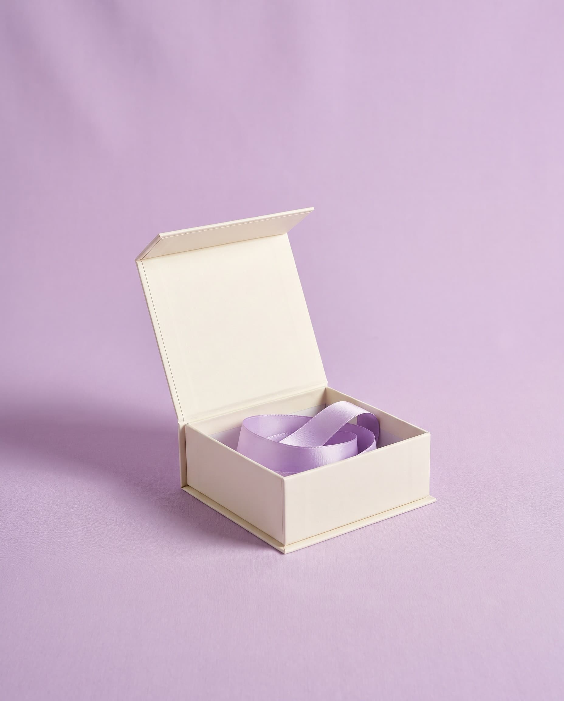 A navy presentation gift box with a gold mark, lid lifted